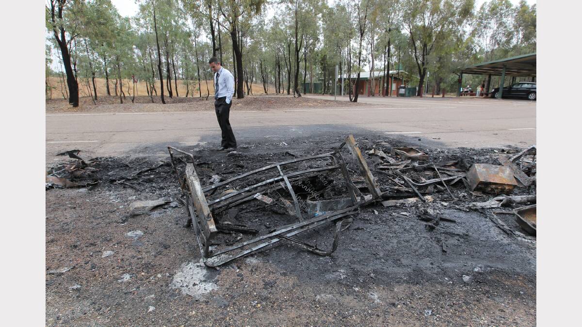 Detective Sergeant Graeme Simpfendorfer surveys the remains of a campervan which was destroyed by fire.