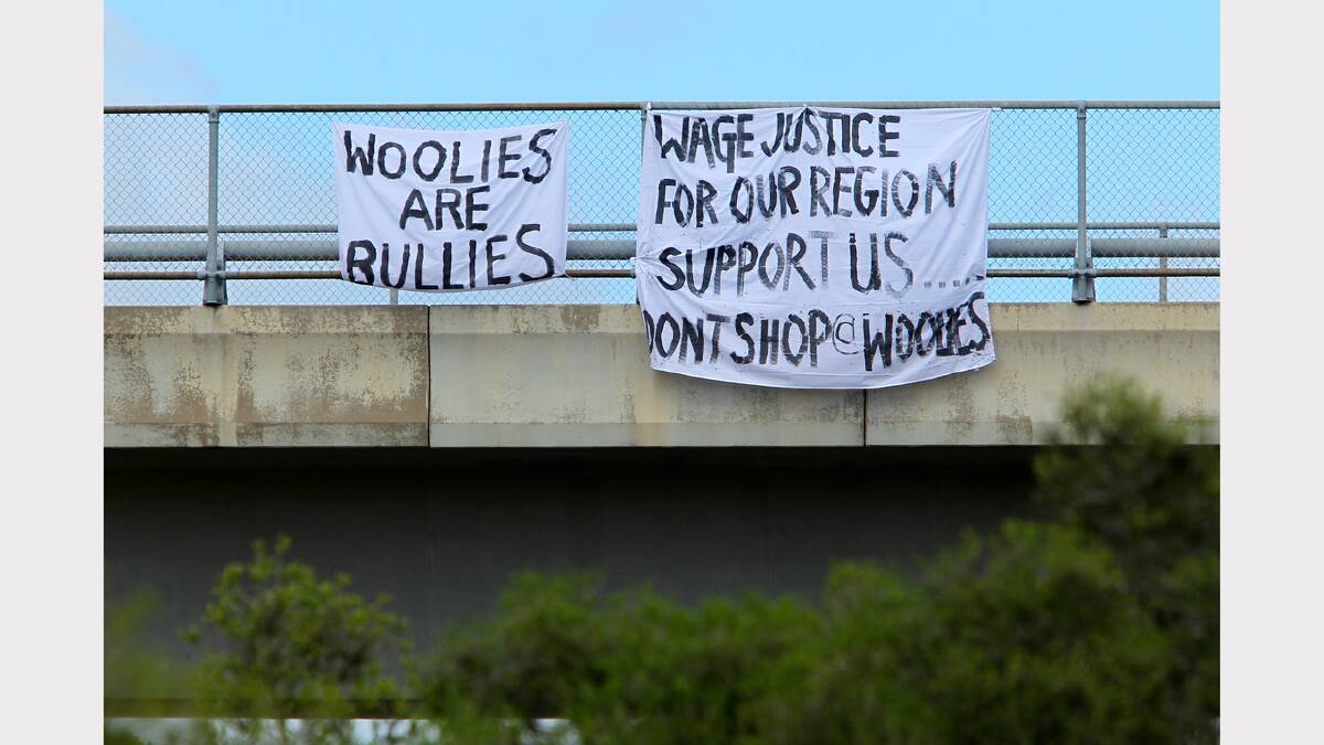 Woolworths workers hung sheets over the Hume Freeway with slogans attacking the supermarket giant. 