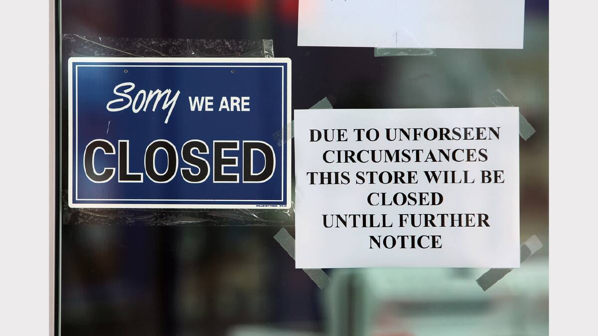  Signs in the window of Warehouse Sales stating that the store has closed due to liquidation.