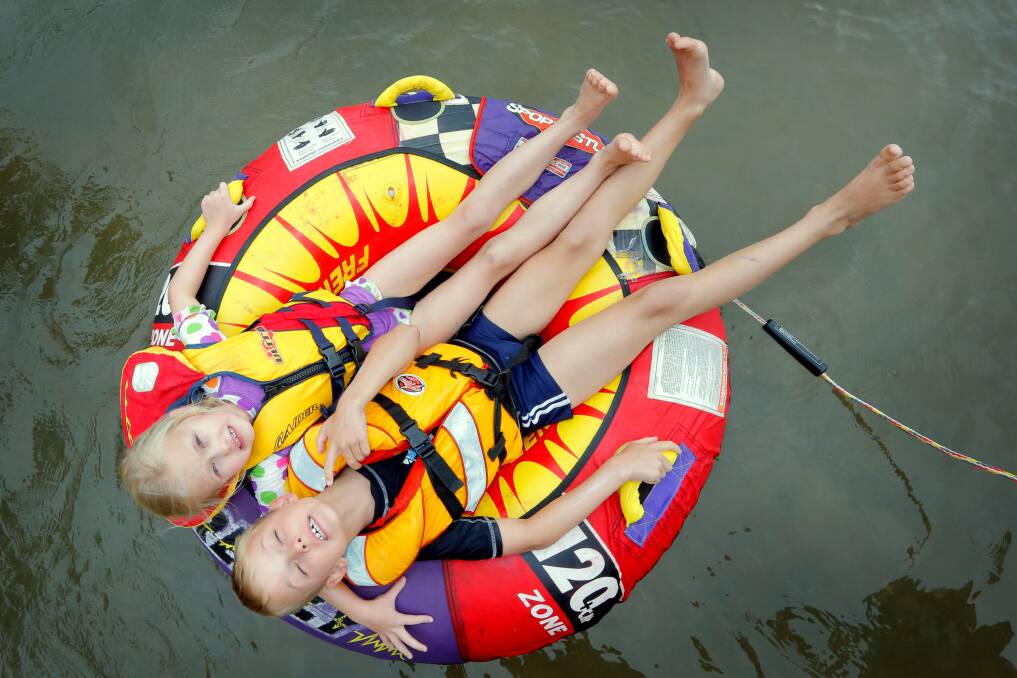 Jindera siblings Ella, 5, and Zak Donoghue, 8, relax as they float down the river being towed by their dad.