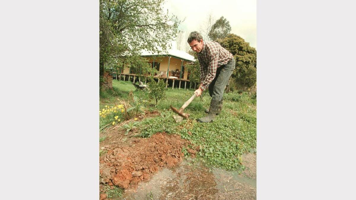 Doug Thompson forming a levee bank at his sick friend's house in Wangaratta.