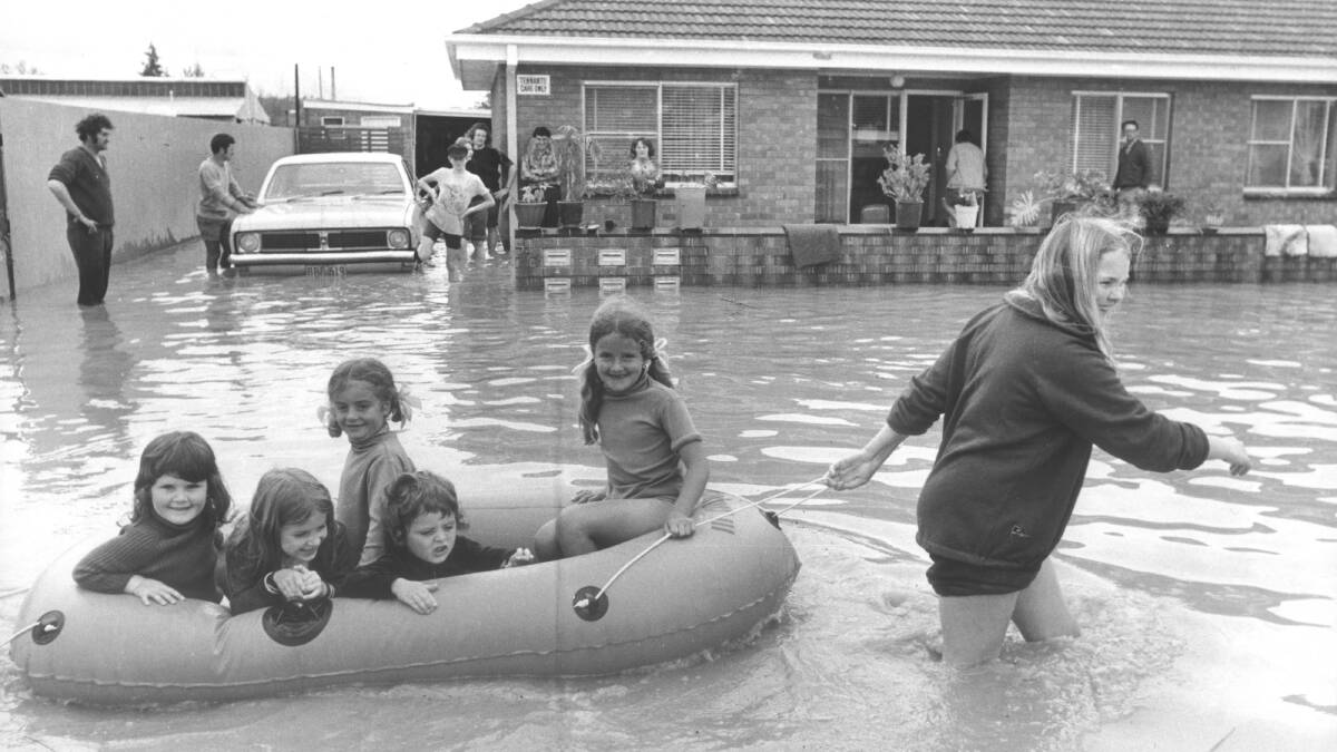 1975 - A lady tows children around in an inflatable boat during the South Albury floods.