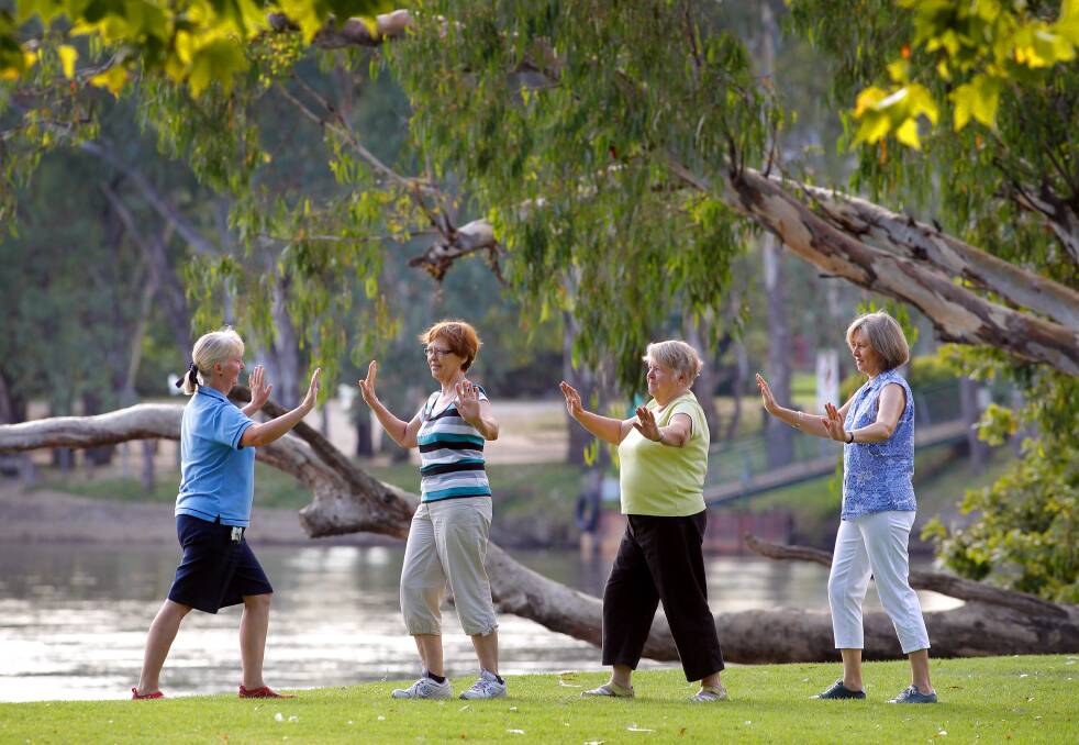 Tai chi instructor Cathy McGlone guides Albury trio Joan Chapman, Julie Ling and Kerry Pryor through their tai chi class at Noreuil Park yesterday. Picture: KYLIE ESLER