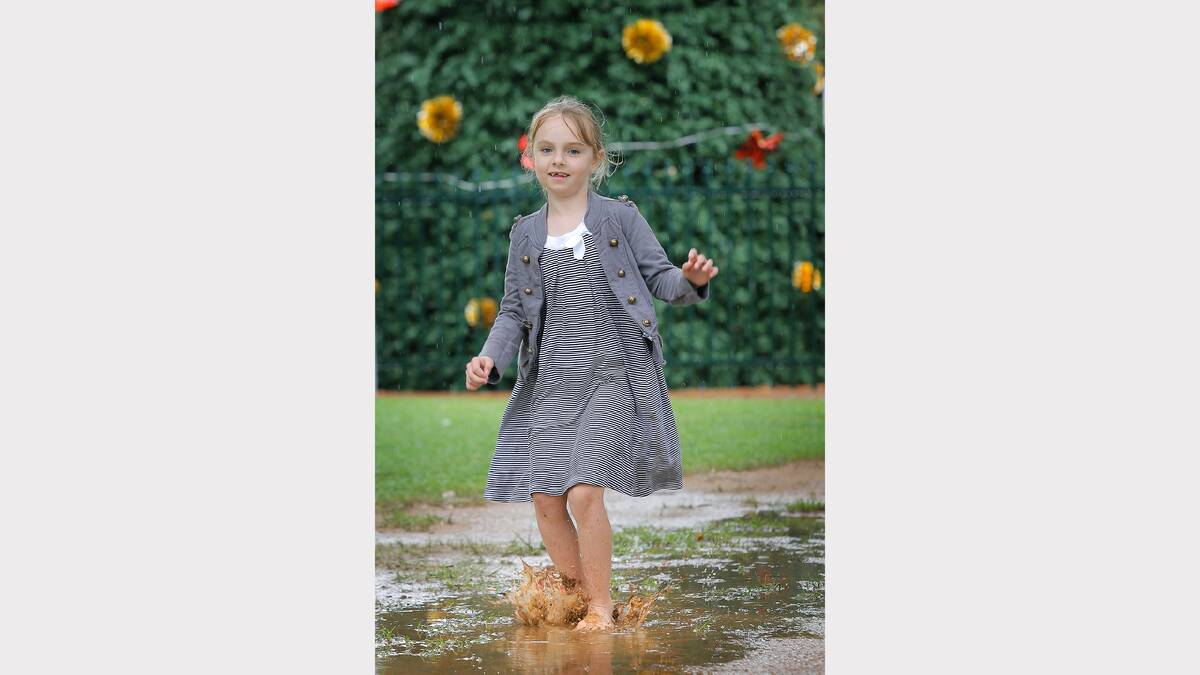 Lavington's Tarnee Keintz, 7, jumped in the puddles at QEII Square during Monday's rain after a week of very hot weather. Picture: TARA GOONAN