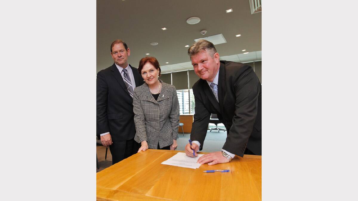 Peter Stephenson being sworn in as council administrator, with MP Tim McCurdy and local government minister Jeanette Powell.