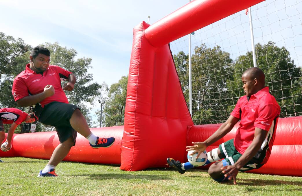 Shihab Mish tries for a goal but goalkeeper Chris Masuda stops it during a practice session on an inflatable soccer pitch at La Trobe university. 