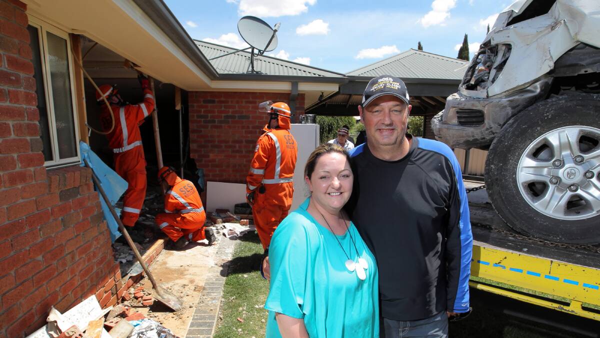  Rachael and Darren Simmons with the remains of their house after the four wheel drive in the picture smashed through their bathroom wall. Picture: DAVID THORPE