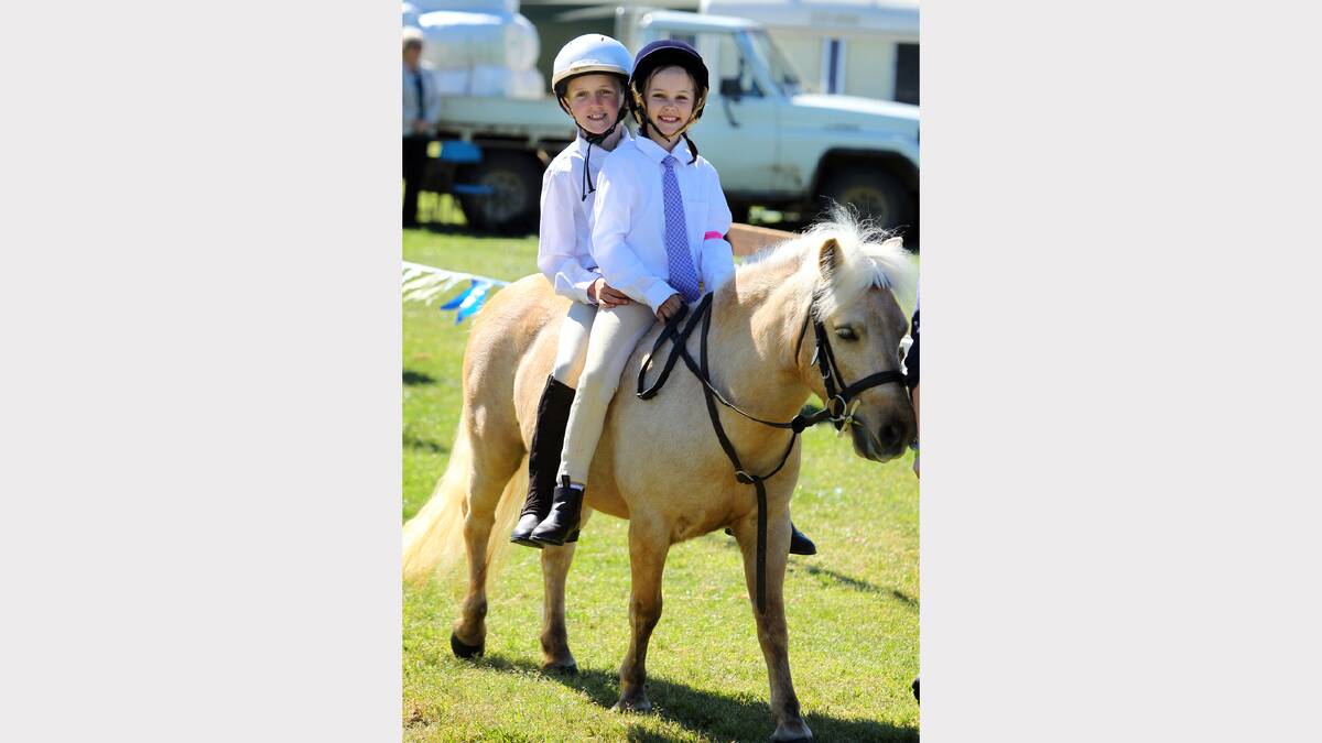Hamish Lieschke, 8, and his sister Izzy, 7, of Walbundrie, riding horse Charlotte in the fun and encouragement section of the show.