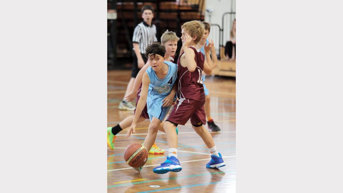 Noah Martin, of Shoalhaven, moves the ball down the court past Matt Langstreth, of Wagga.