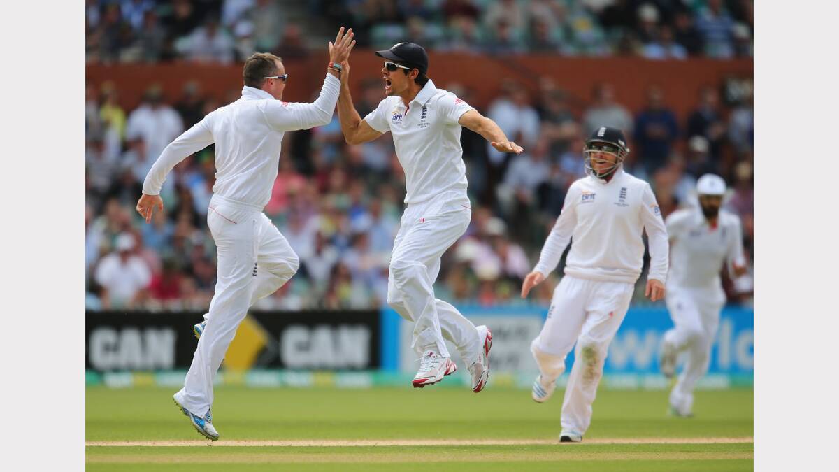 England's Graeme Swann celebrates with captain Alastair Cook after dismissing Australia's Chris Rogers.