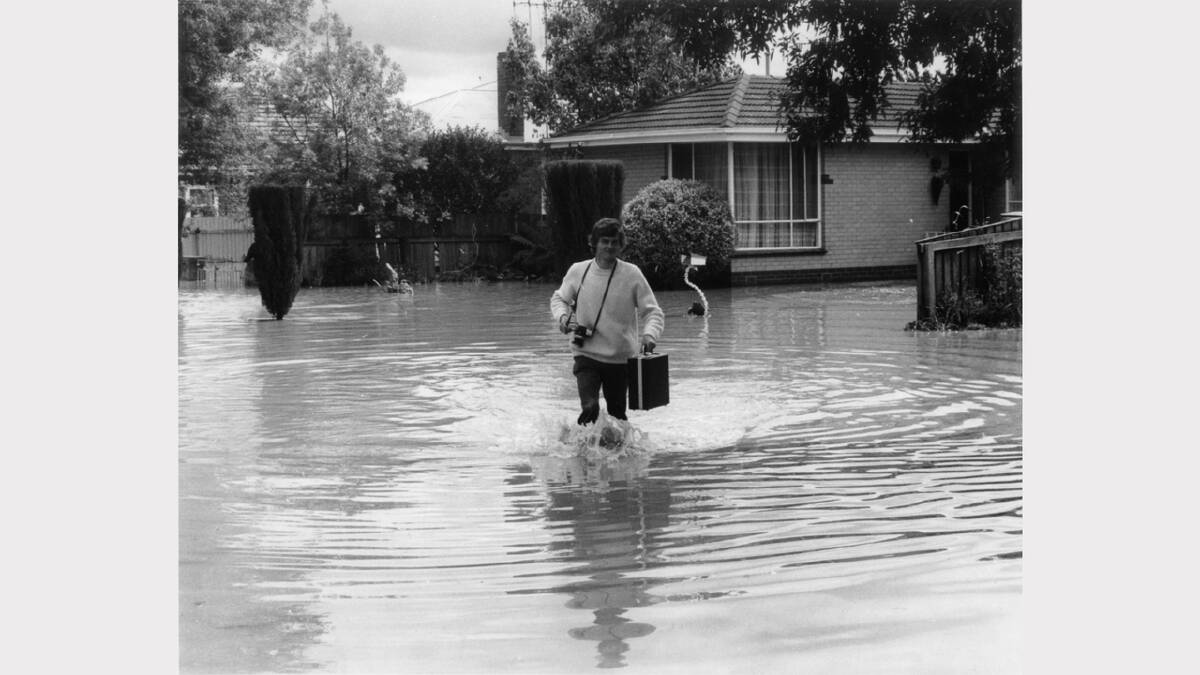 1975 - South Albury. Border Mail photographer Peter Merkesteyn preparing to work in the floods.