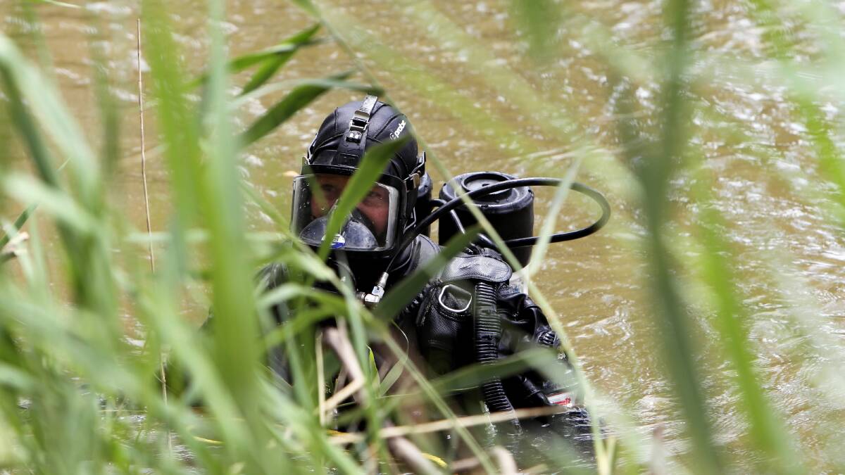 Police search and rescue squad divers sweep the bed and banks of the Murray River at Cobram for property stolen on Christmas night. Pictures: MARK JESSER