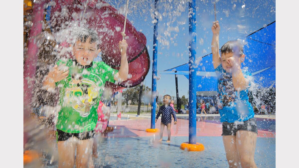 Oberon twins Rhys and Jacob Braun, 4 1/2 years old cool off under the giant tap showers at the pool. 