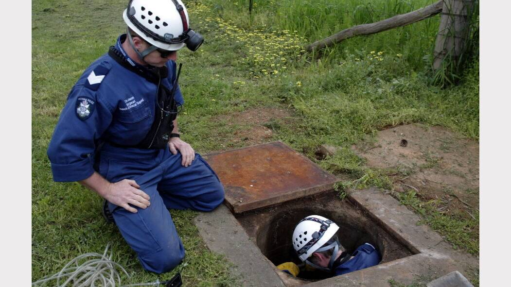 2003 - A Police officer from the Search and Rescue Squad goes down into the drain to find any clues in the disappearence of Daniel Thomas, 2, who has been missing since last Friday afternoon in Myrtleford, VIC.
