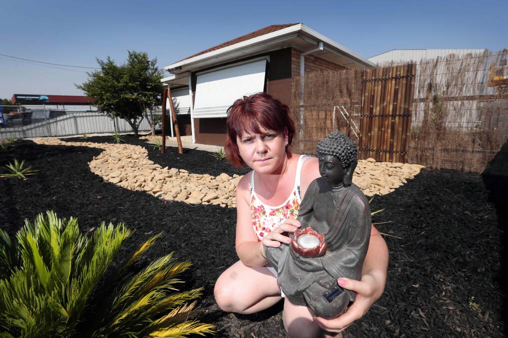 l Michelle Jackson has one Buddha solar light left after six others and a water feature were stolen. Picture: MATTHEW SMITHWICK 