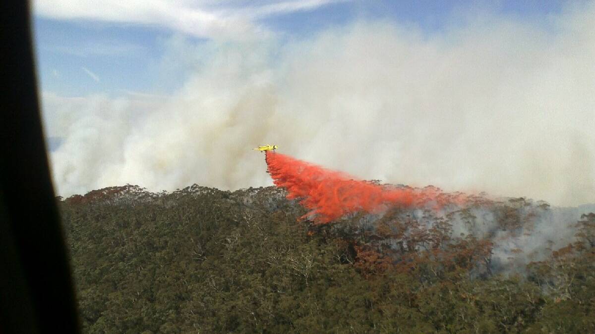 A firefighting aircraft bombs the Wirritin fire north-west of Batemans Bay.