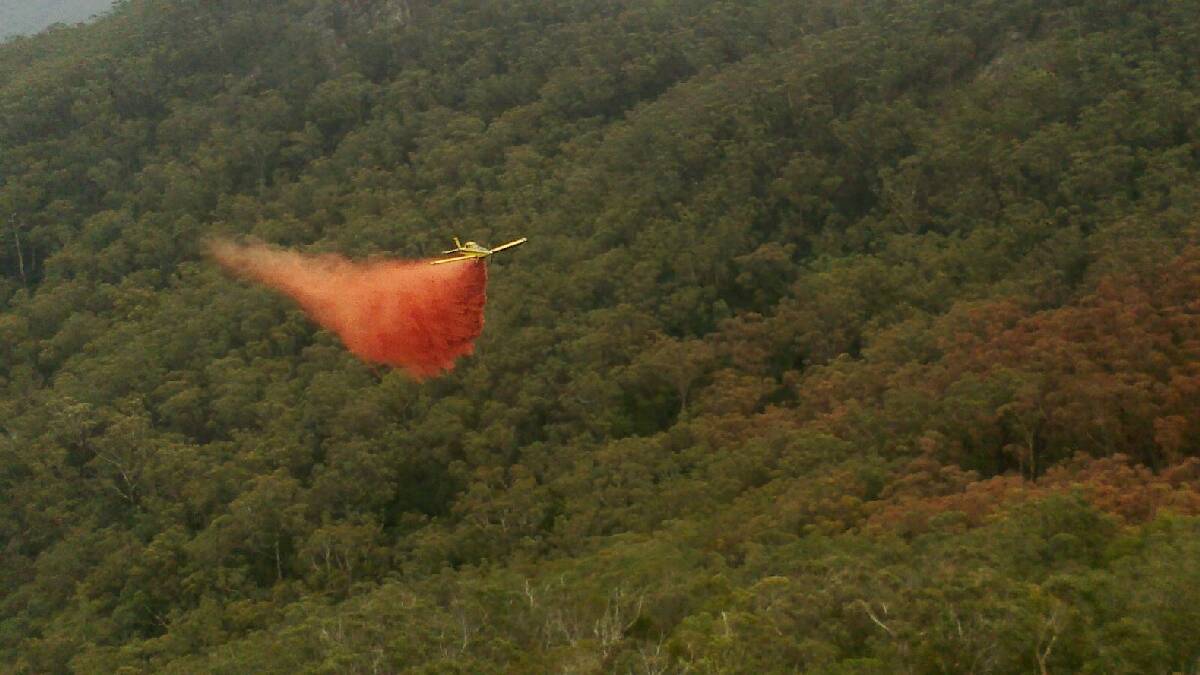 A firefighting aircraft bombs the Wirritin fire north-west of Batemans Bay.