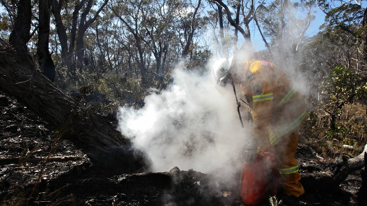 Tim Parsley from from Wentworth Falls RFS mopping up after a backburn west of Hat Hill Rd in Blackheath in preparation for worsening conditions today. Picture: Dallas Kilponen
