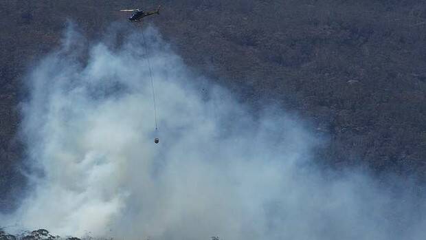 Water bombing helicopters have commenced their work on fires which have flared up around the State Mine fire near Berambing. The Sydney Morning Herald Picture: Wolter Peeters 