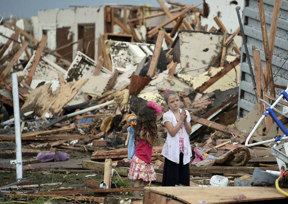 Two girls stand in rubble after a tornado struck Moore, Oklahoma, May 20, 2013. Photo: REUTERS/Gene Blevins