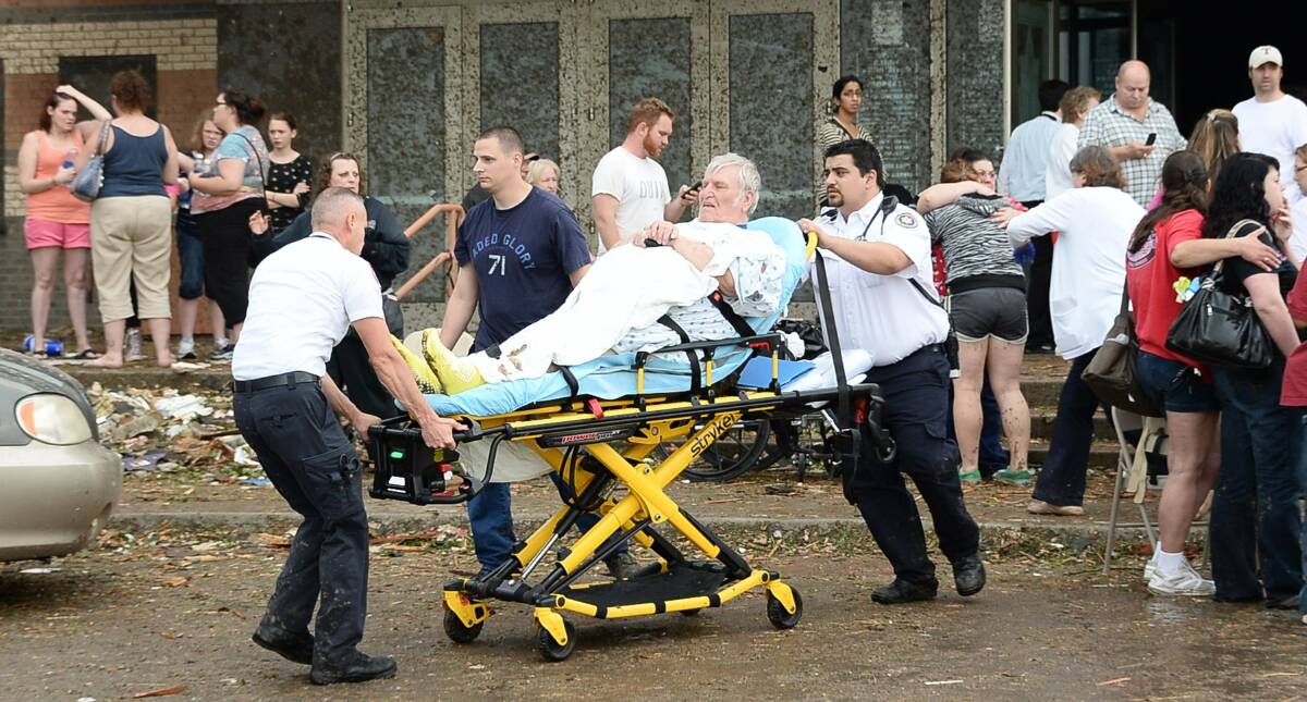 A man is taken away from the IMAX theater that was used as a triage area after a tornado that destroyed buildings and overturned cars struck Moore, Oklahoma, May 20, 2013. Photo: REUTERS/Gene Blevins