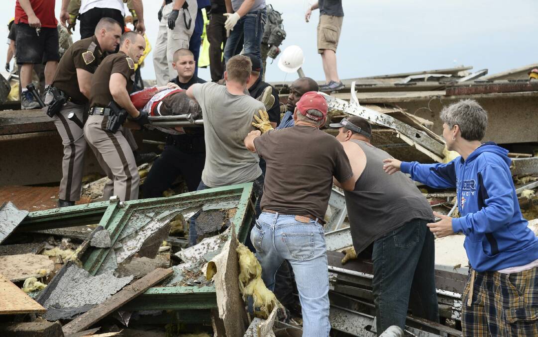 Rescue workers help free one of 15 people trapped in a medical building at the Moore hospital complex after a tornado tore through the area of Moore, Oklahoma May 20, 2013. Photo: REUTERS/Gene Blevins