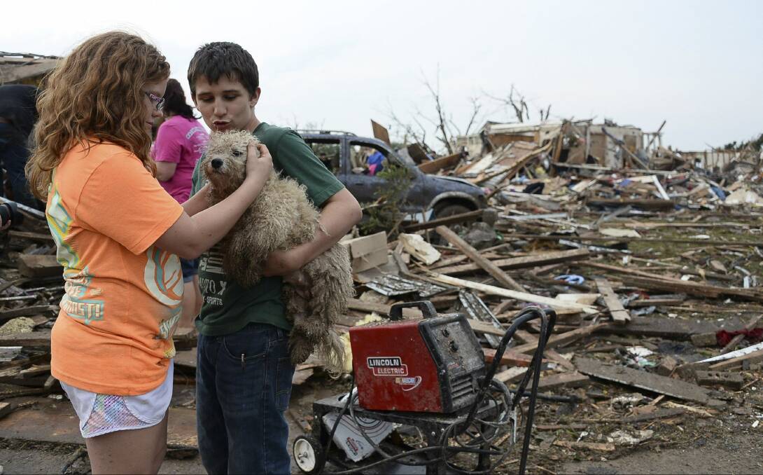 Abby Madi and Peterson Zatterlee comforts Zatterlee's dog Rippy, after a tornado struck Moore, Oklahoma, May 20, 2013. REUTERS/Gene Blevins
