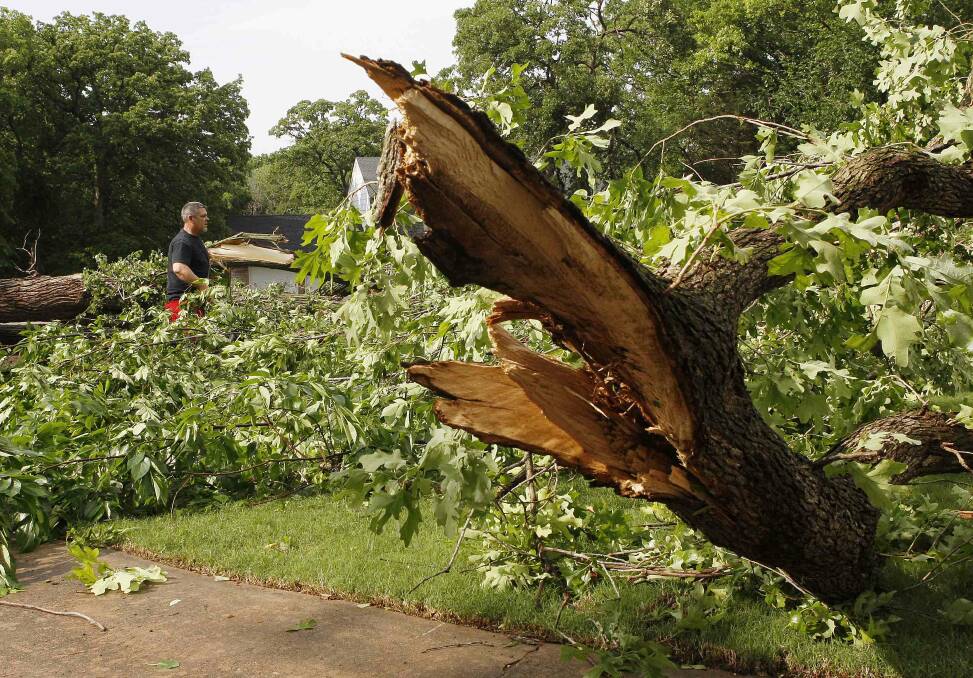 Bob Cameron of Edmond, Oklahoma, helps a neighbor move downed trees after a tornado swept through the eastern part of Edmond. Photo: REUTERS