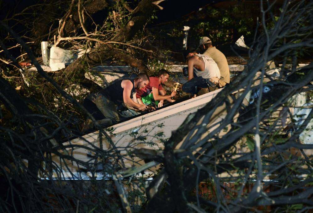 Residents help repair the roof of their neighbour's house which was damaged by a fallen tree when a tornado swept through Shawnee, Oklahoma. Photo: REUTERS