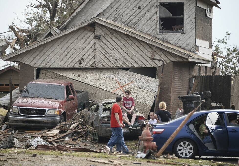 People are seen next to a damaged house and vehicles along a street after a huge tornado, in Moore, Oklahoma May 20, 2013. Photo:  REUTERS/Gene Blevins