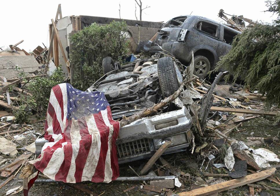 An American flag lies on top of an overturned car after a tornado struck Moore, Oklahoma, May 20, 2013. Photo: REUTERS/Gene Blevins