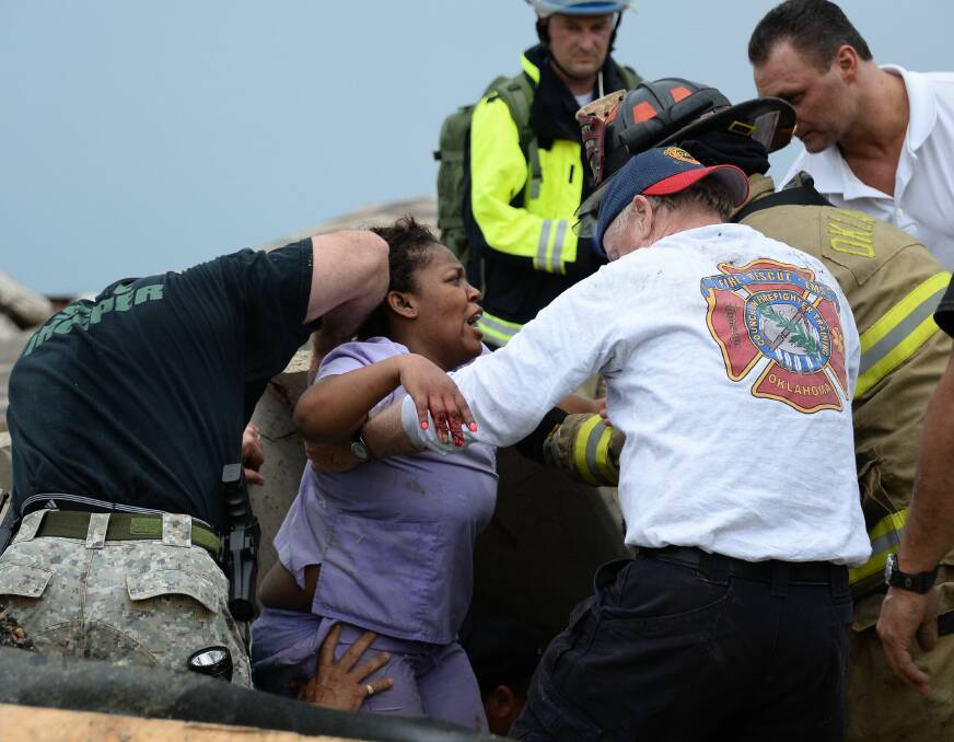 Rescue workers help free one of the 15 people that were trapped at a medical building at the Moore hospital complex after a tornado tore through the area of Moore, Oklahoma May 20, 2013. REUTERS/Gene Blevins