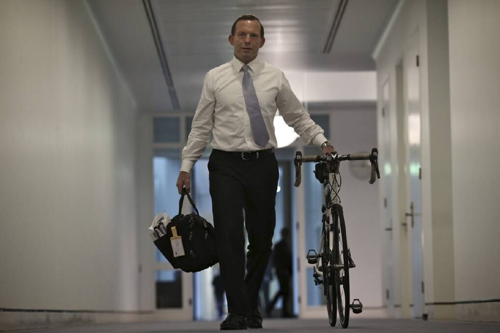 Tony Abbott wheels his bicycle from his old office to his Prime Ministerial office at Parliament House. Photo: Alex Ellinghausen