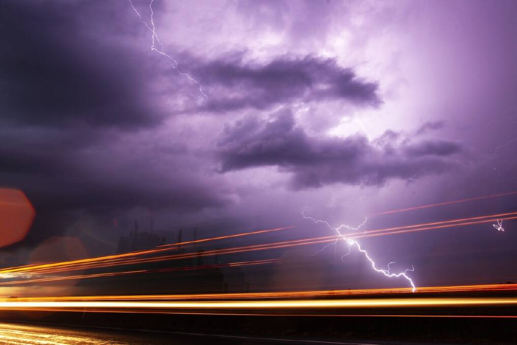Lightning silhouettes a semi trailer which also leaves a light trail, this storm was just one of many stretching from QLD through NSW and into VIC. Photo: Nick Moir