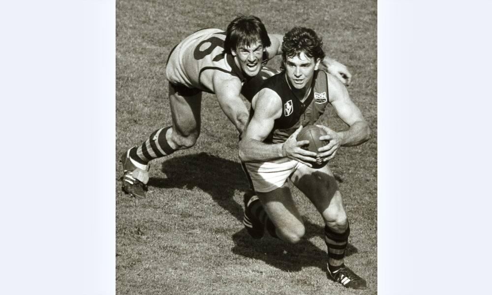 Merv Neagle is pursued by Terry Wallace in the 1983 grand final between Hawthorn and Essendon. PICTURE: Fairfax.