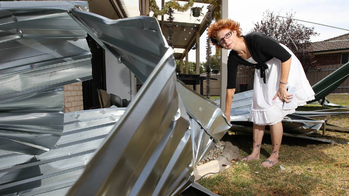 Donna Carroll inspects the damage in her backyard from yesterday’s mini-tornado. Picture: BEN EYLES