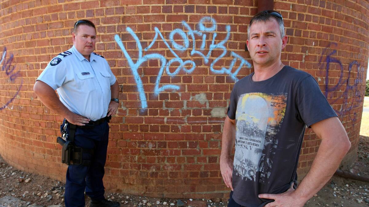 Leading Sen-Constable Darren O’Neill, of Rutherglen police, and Stephen Ronnfeldt, from Friends of the Wine Bottle, are disappointed the water tower has been defaced. Picture: MATTHEW SMITHWICK