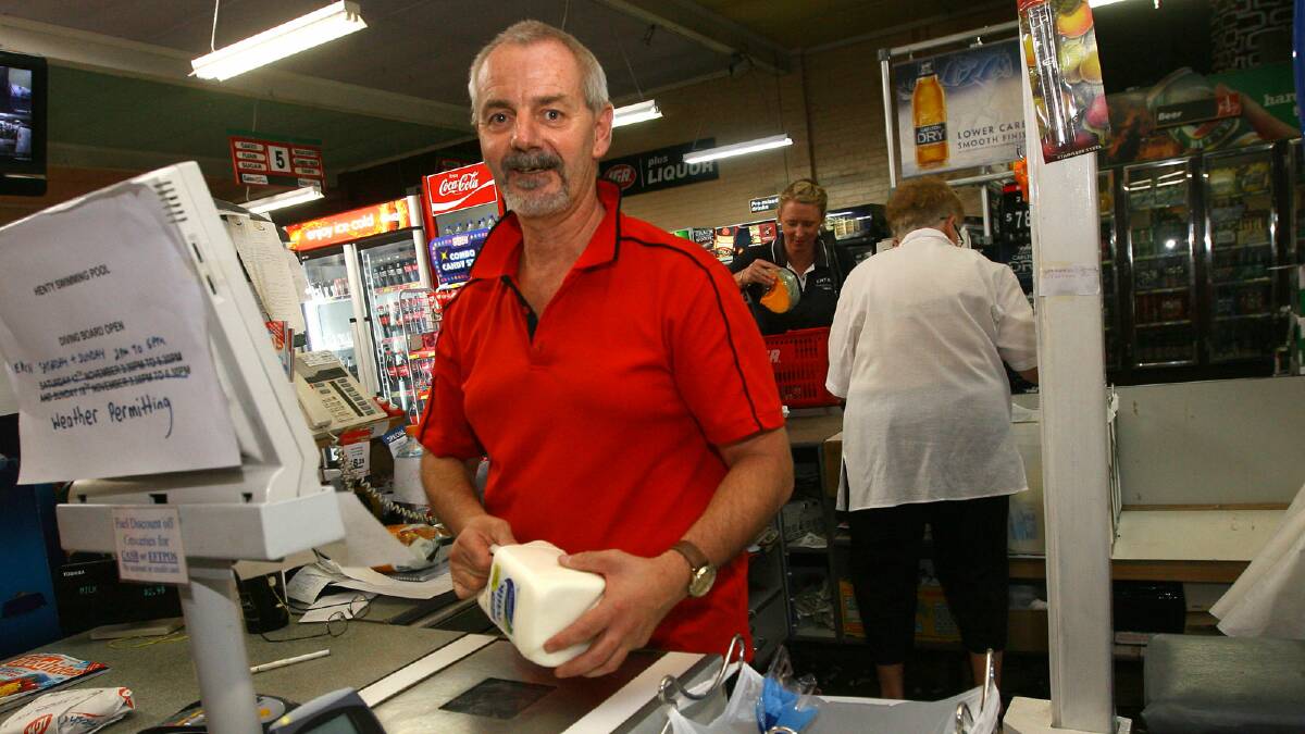 Ken Jones was manning the cash register at Dale’s IGA store in Henty when the fire threat came. People were buying up food and water and preparing to evacuate the town. Picture: BEN EYLES