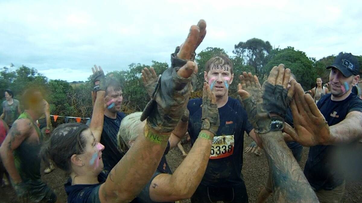 The team celebrates conquering the Mud Mile.
