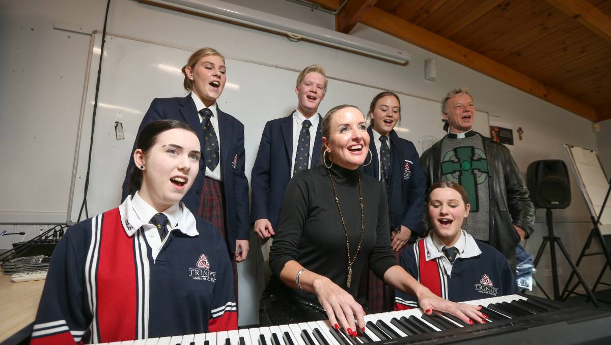 SCHOOL SONGBIRDS: Simone Waddell and Father Peter MacLeod-Miller with Trinity Anglican College year 12 students. Picture: JAMES WILTSHIRE