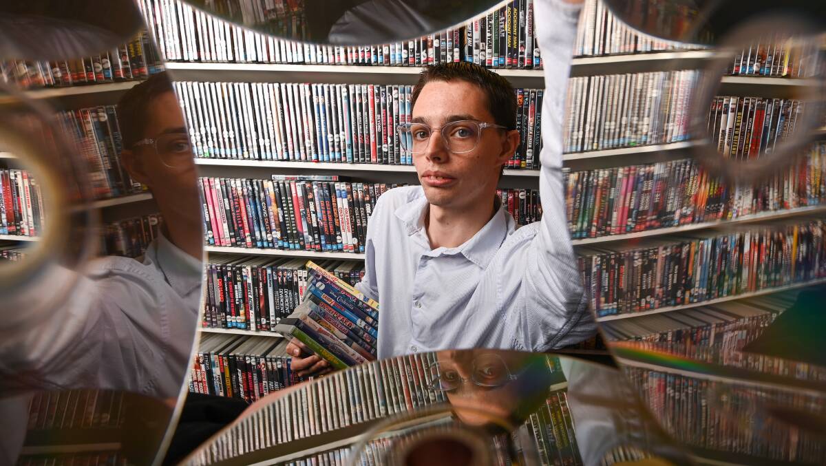 BACK ON THE SHELF: Bira Flix employee Andrew Gillam is disappointed the rental store is closing. Pictures: MARK JESSER
