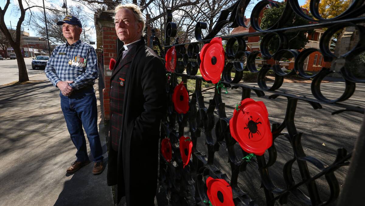 IN REMEMBERANCE: Graham Docksey and Father Peter MacLeod-Miller paid their respects during a small ceremony for Vietnam Veterans' Day. Picture: JAMES WILTSHIRE