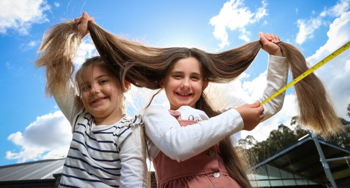 JUST A TRIM: Billie Muggivan, 6, pictured with her younger sister Indi, 4, is chopping off 36 centimetres of hair to raise money for Hair with Heart. The charity helps to provide wigs for young people in cancer treatment. Pictures: JAMES WILTSHIRE