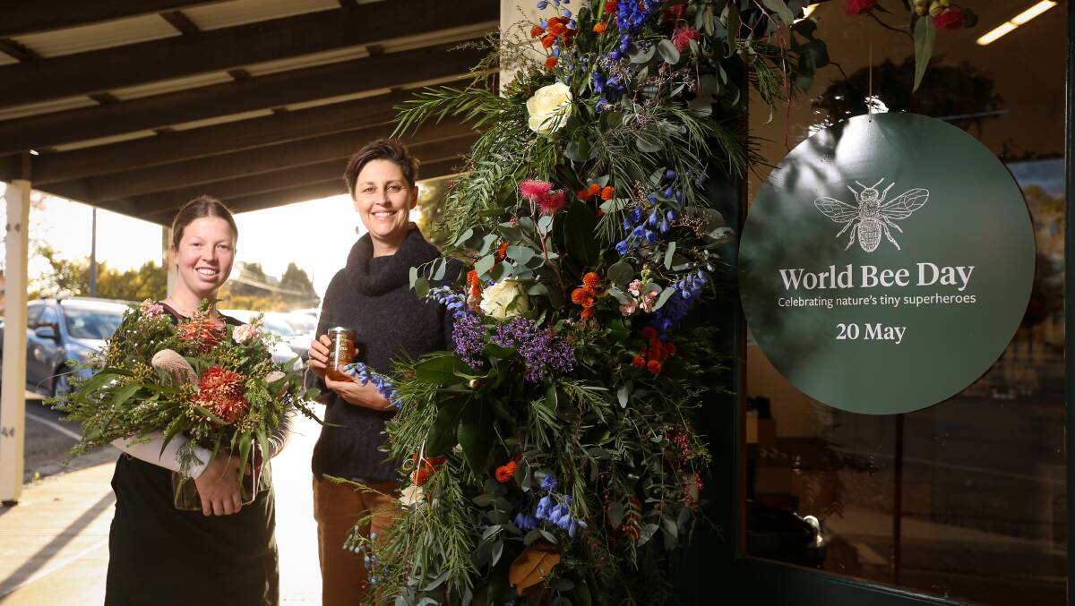 LET IT BEE: Chloe Tate and Gina Bladon with the Scout's Garden flower display at the Beechworth Honey Store for World Bee Day. Picture: JAMES WILTSHIRE