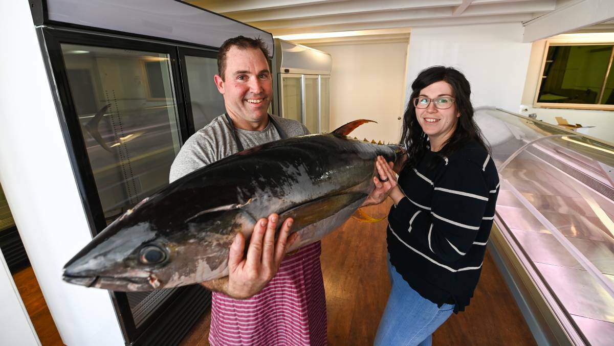 CAUGHT: Jeffrey and Morgan Barton with a 35kg yellowfin tuna were optimisitic when they opened their store in May last year, but now they've had to sell. Picture: MARK JESSER