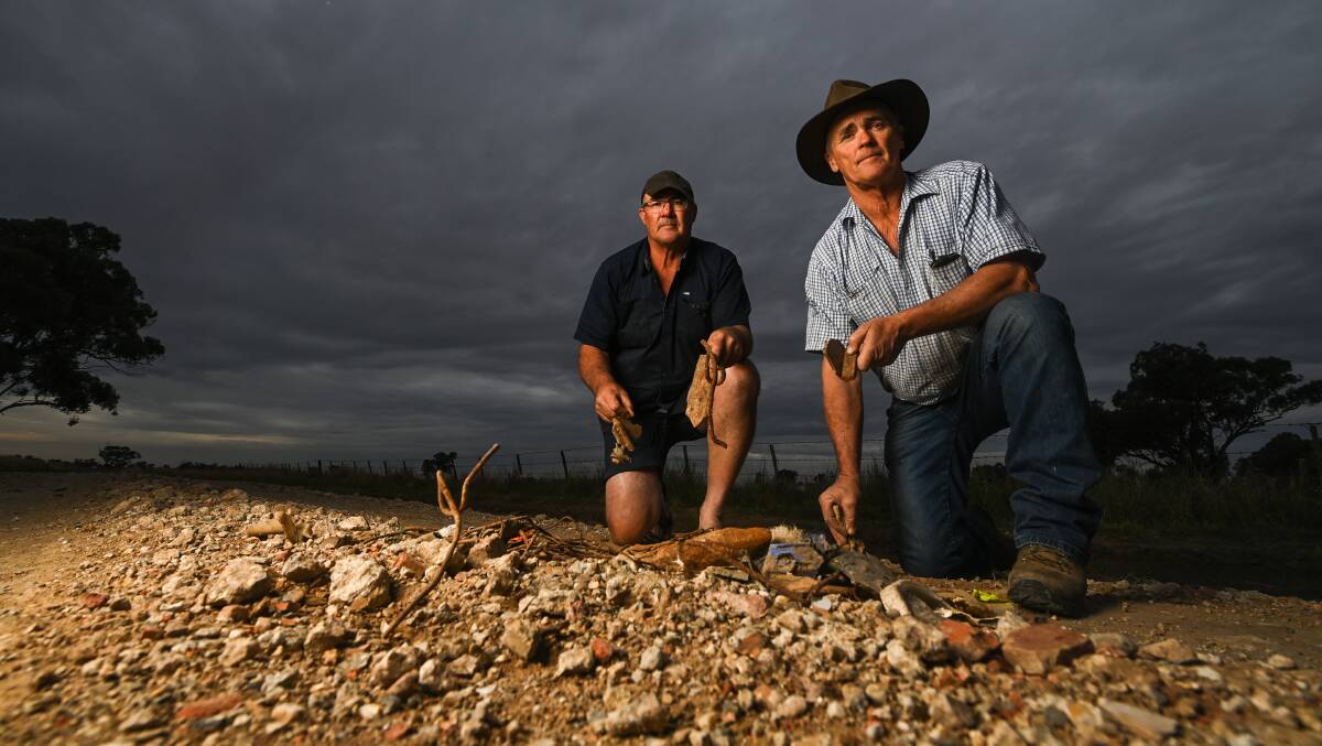 UNSAFE: Federation Council placed metal and concrete into pot holes on Pattersons Road Rennie after running out of gravel. Nearby farmers and brothers Jack and Bill Ferguson pose with the damage. Picture: MARK JESSER