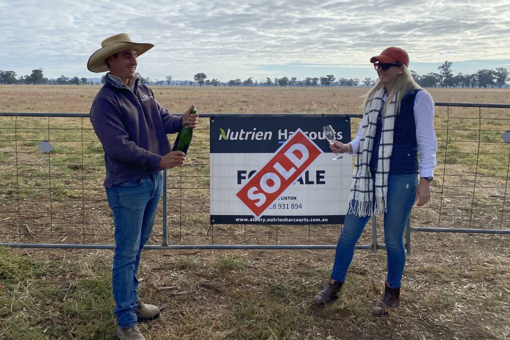 CELEBRATING: Thomas Robertson and Stephanie Clancy pop champagne to celebrate their recent purchase of land near Culcairn.