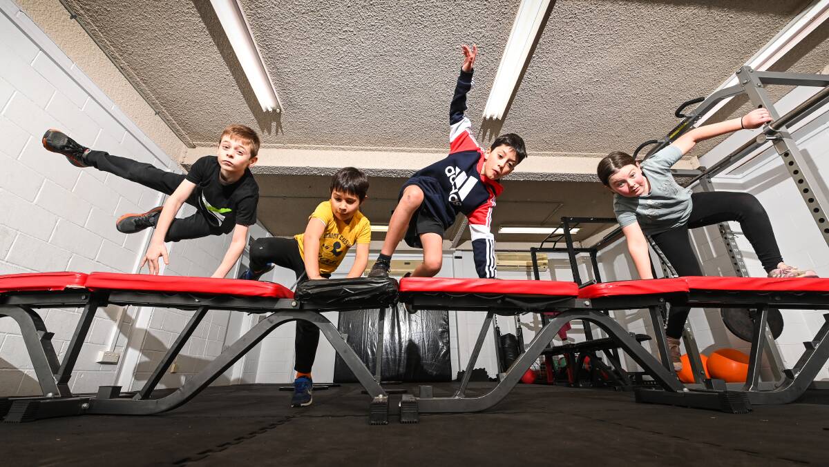  VAULTING FORWARD: Tyler Beaston, 9, Ali Muhieddine, 6, Theo Swinson, 11 and Lillyann Sommer, 11 vaulting over obstacles in the parkour class. Picture: MARK JESSER