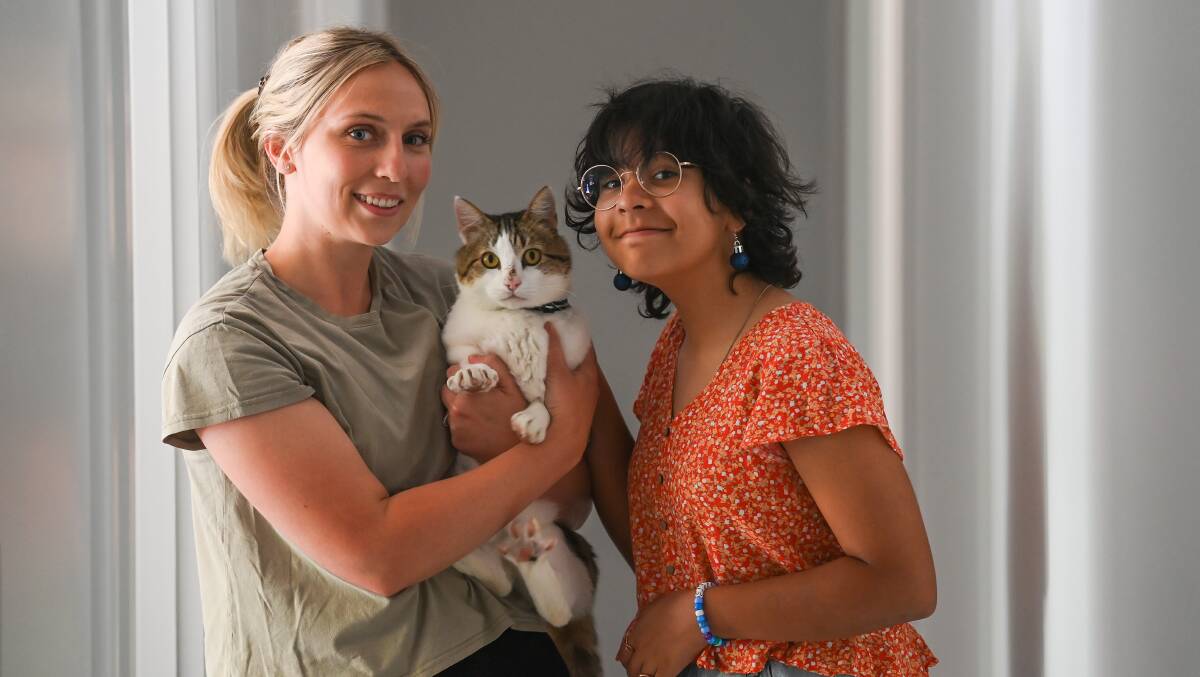 IN LOVING ARMS: Emily Grealy and sister Bella Andre, 11, reunited with Marley the cat after being gone for five years. Picture: MARK JESSER