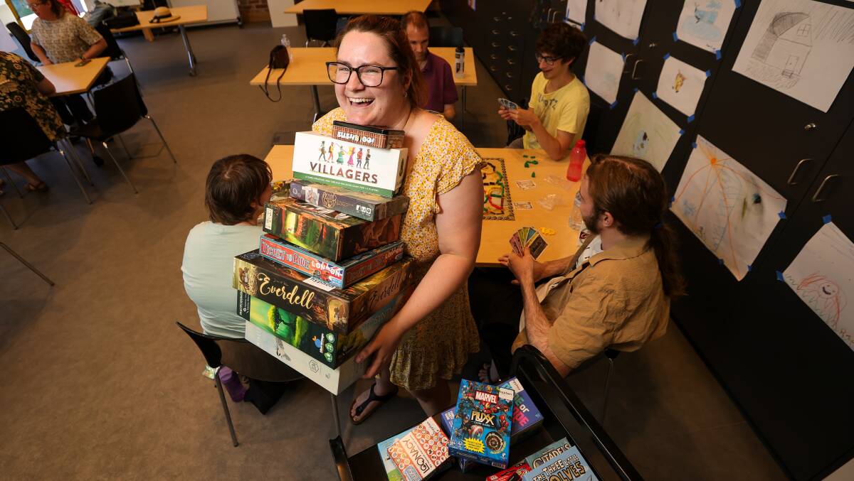 HuMM BuGG founder and president Lyss Cole balances a huge number of board games at the groups January meeting. Picture by James Wiltshire